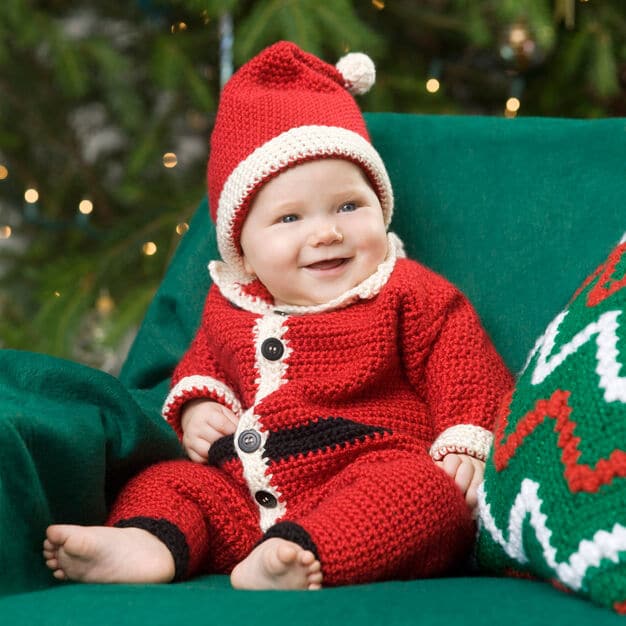 A small child wearing a santa suit