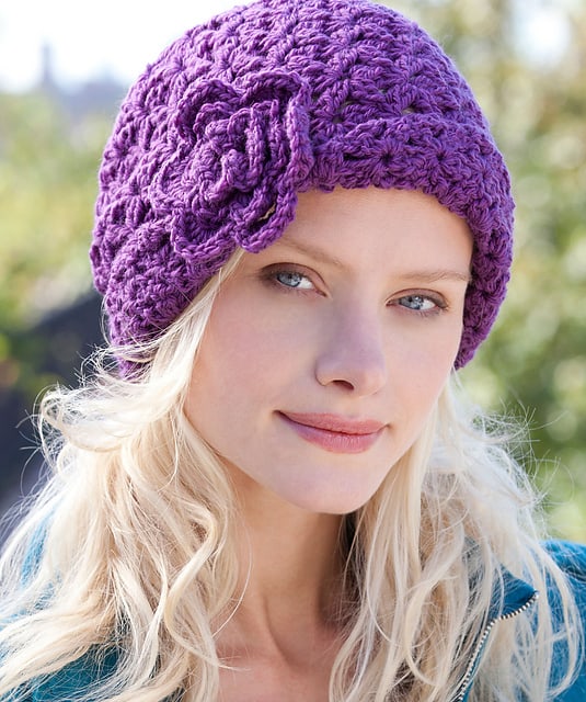 A close up of a woman wearing a purple hat