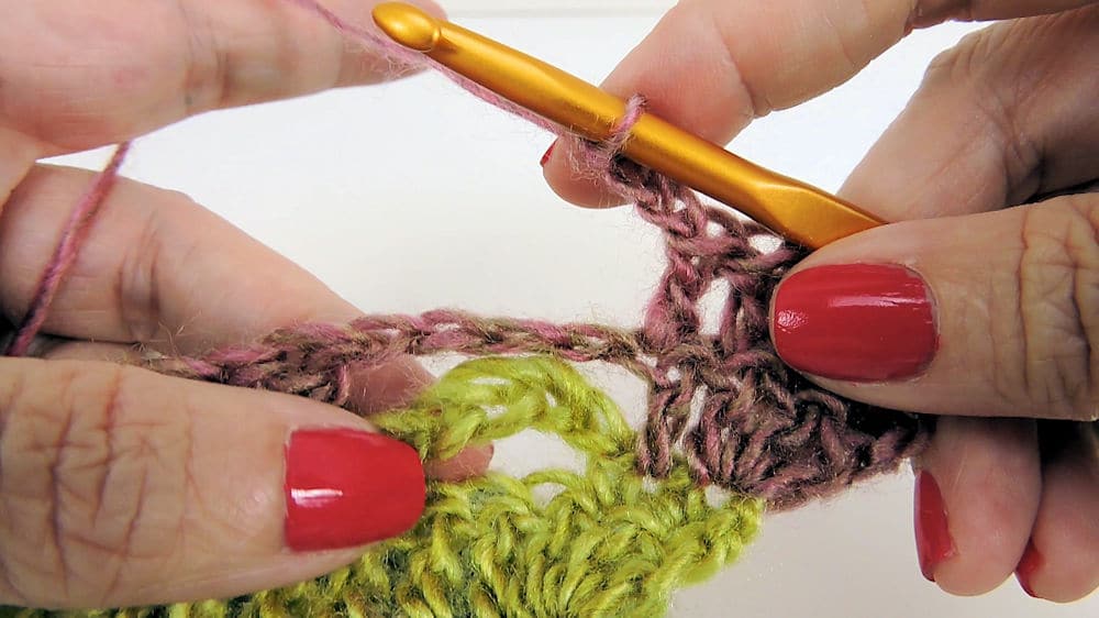 A close up of a hand crocheting
