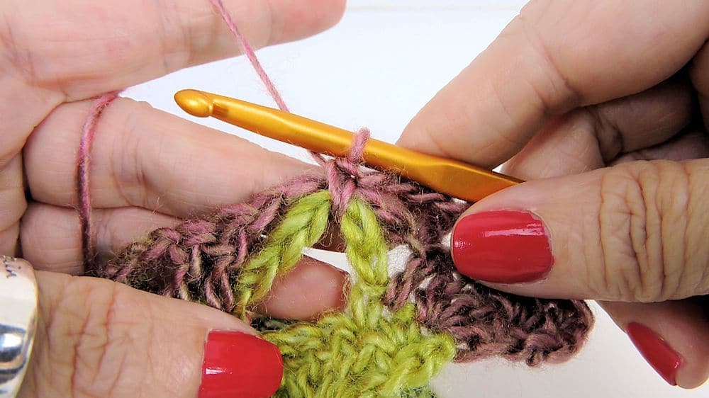 A close up of a hand crocheting